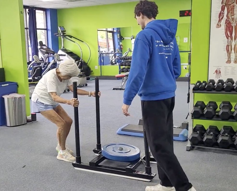 Repke trainer Noah coaching a senior client through a sled push